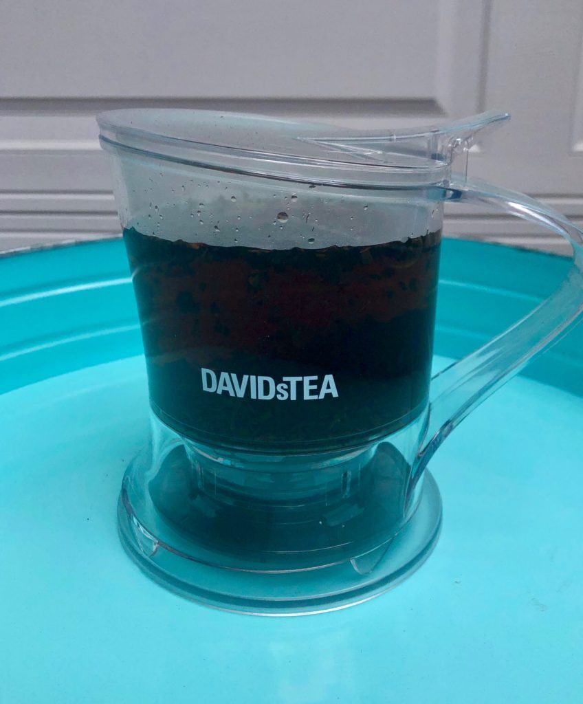 The Steeper by DAVID's TEA filled with Cream of Earl Grey Tea on a blue tray