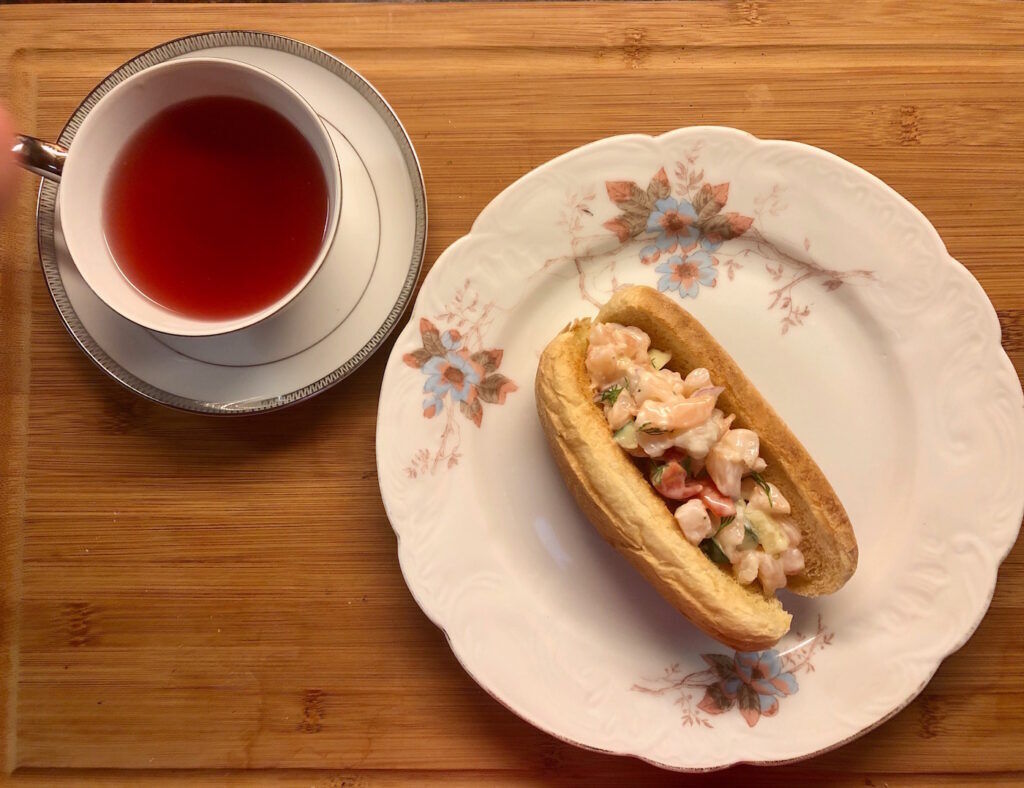 Shrimp Roll on a plate and Stash Wild Raspberry Hibiscus tea in a tea cup and saucer
