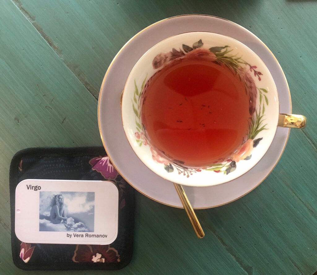 Virgo Fandom Adagio tea in a cup with a saucer and a tea sampler tin