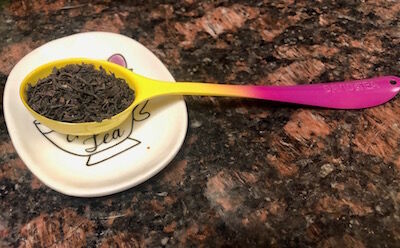 Yellow and pink David's tea perfect tea spoon with tea and a tea disposal dish